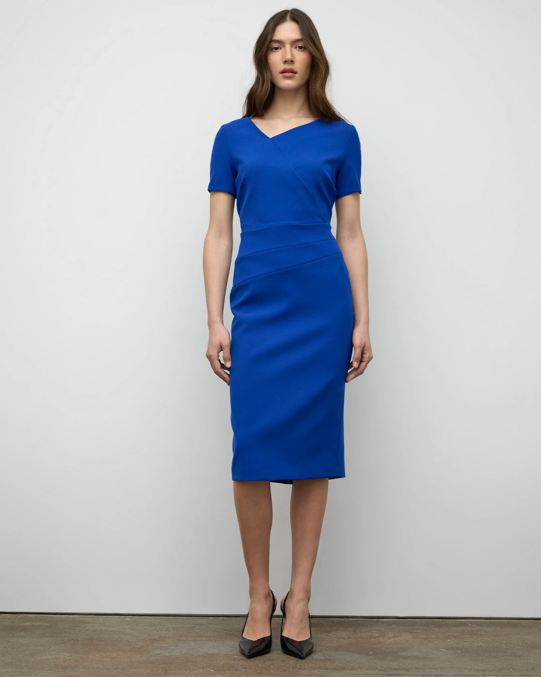 Woman wearing a blue dress against a plain white background