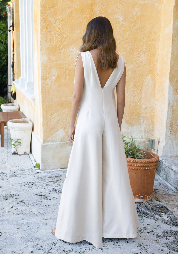 back profile view of woman wearing ivory sleeveless silk jumpsuit