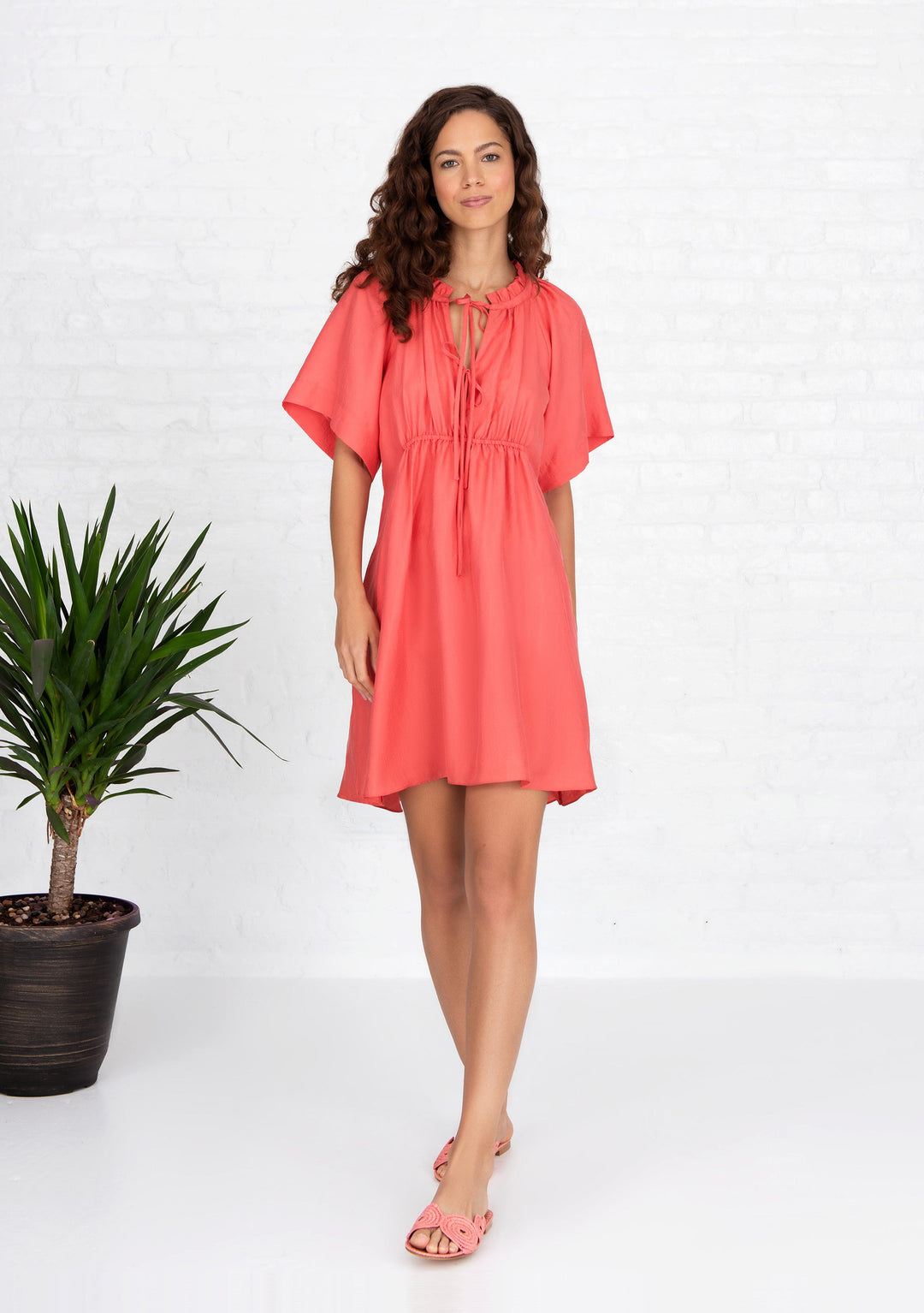 woman wearing coral short sleeved silk dress handwoven